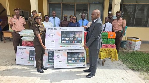 -Mr Brantuo presenting the items to Mrs Ashong-Mettle, while other officers and employees of the bank look on.