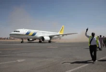 Airport ground workers greet the first domestic Sudan Airways flight landing from Port Sudan