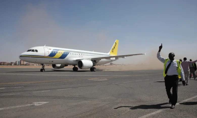 Airport ground workers greet the first domestic Sudan Airways flight landing from Port Sudan
