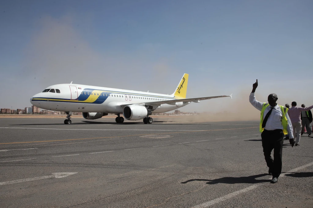 Airport ground workers greet the first domestic Sudan Airways flight landing from Port Sudan