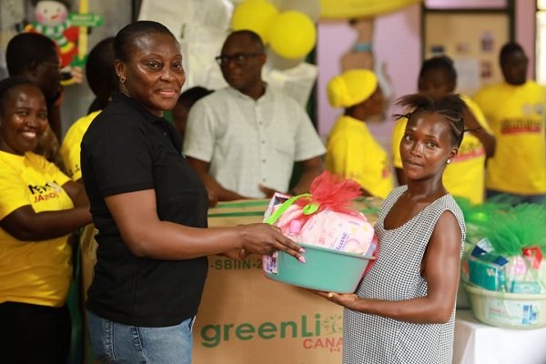 Ms Sampong (left) presenting a baby hammper to one of the nursing mothers at the Cape Coast Teaching Hospital