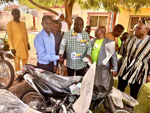 Mr Opoku (middle) handing over one of the motorbikes to a beneficiary