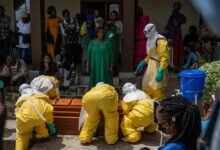 Family members of an Ebola victim mourn as the coffin is taken away for burial in Congo