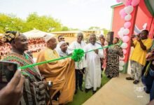 Dr Adam (in smock) being assisted by Mr Dokurugu and other dignitaries to open the facility