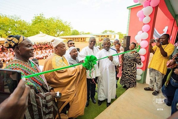 Dr Adam (in smock) being assisted by Mr Dokurugu and other dignitaries to open the facility