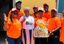 The team handing over a hamper to a beneficiary (second from left) during the house visit