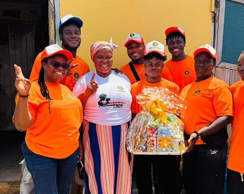 The team handing over a hamper to a beneficiary (second from left) during the house visit