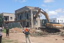 An execavator demolishing one of the illegal structures at the Ramsar site