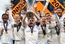 John McGinn lifts the trophy as he celebrates with teammates