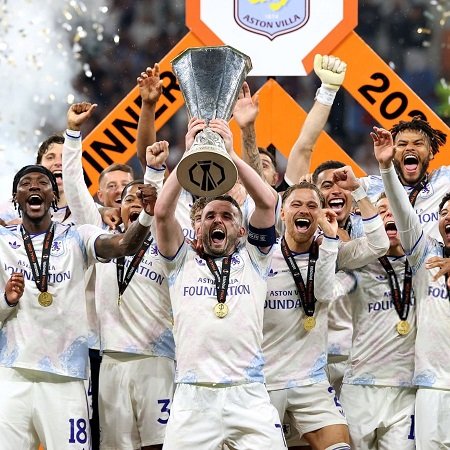 John McGinn lifts the trophy as he celebrates with teammates