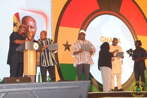President Mahama (left) and some ministers of state trying their hands on the e-Visa Portal platform