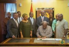 President Mahama assenting to the bill. With him are Mr Julius Debrah (right) and some ministers of state