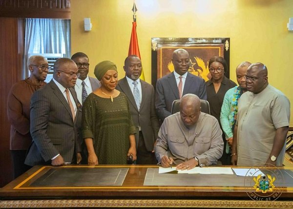 President Mahama assenting to the bill. With him are Mr Julius Debrah (right) and some ministers of state