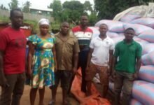 Rice farmers infront of the bags of unsold rice