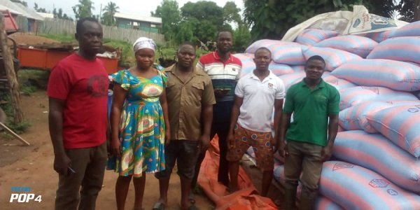 Rice farmers infront of the bags of unsold rice