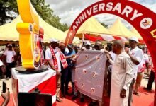 Mr Mustapha being assisted by other dignitaries to unveil the school's anniversary cloth