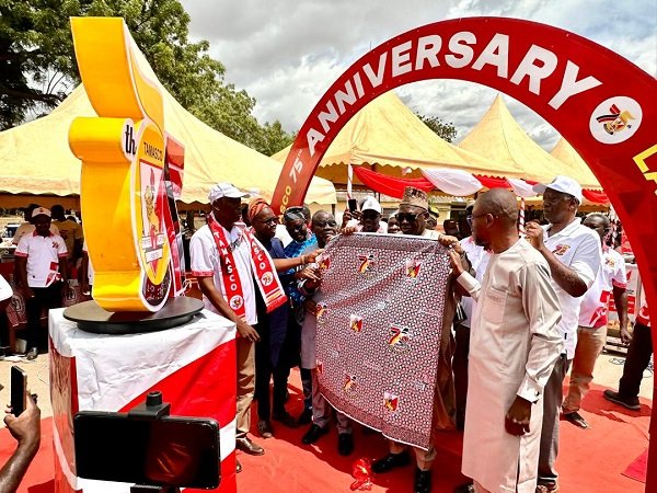 Mr Mustapha being assisted by other dignitaries to unveil the school's anniversary cloth