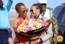 Dr Zanetor (right) receiving a bouquet of flower on her arrival from Mrs Cudjoe, MP of Ada