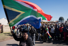 A demonstrator waves South Africa's flag during a protest