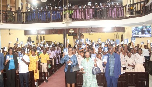 Officials from the Bible Society of Ghana and students raising their Bibles after the distribution at the launch. Photo Ebo Gorman