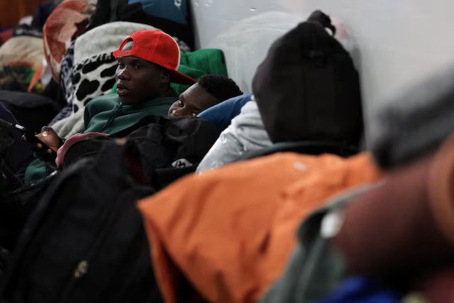 Displaced migrants shelter in a hall, following an escalation in anti-immigrant protests