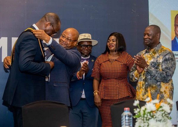 • Mr Akafia (second from left ) adorns Mr Attakumah with a sash as he hands over the GCM Presidency. Looking on are Mr Armah Kofi-Buah (right) and other dignitaries