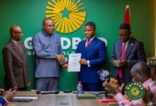 Mr. Sammy Gyamfi (second from right) and Mr. Brogya Genfi exchanging greetings after signing the agreement