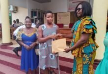 Mrs Mawutor (right) presenting money to one of the beneficiaries