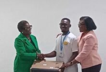 Prof. Rosina Kyeremanten (right) presenting the laptop to one of the scholars