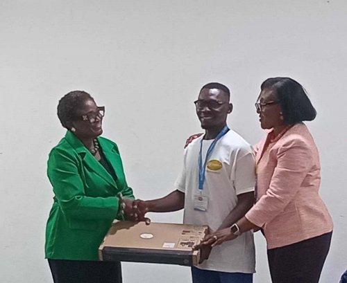 Prof. Rosina Kyeremanten (right) presenting the laptop to one of the scholars