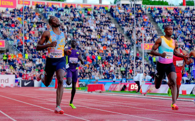 Letsile Tebogo crossing the finish line ahead of Gout Gout during the men's 200m