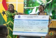 Nana Oye Bampo Addo, (left) presenting the dummy cheque to Ms Darko-Opoku