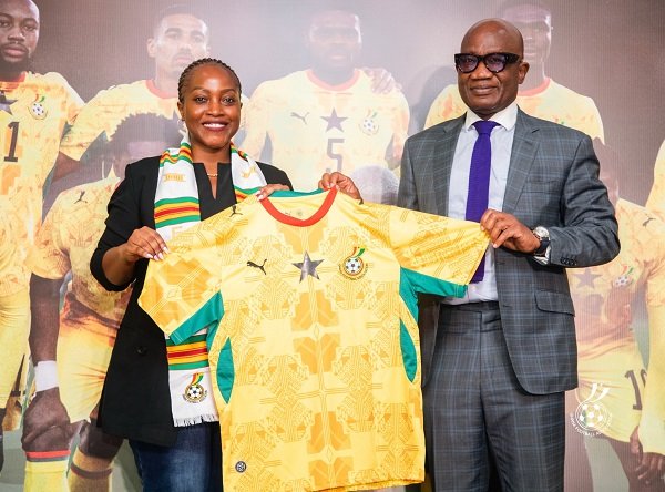Madam Ndanyungu receives a signed Black Stars jersey from Mr Addo