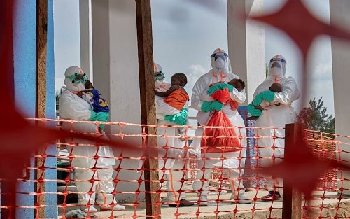 Medical workers dressed in personal protective equipment (PPE) carry children tested and cleared off from Ebola from Saint Nicholas orphanage, at the Centre Medical Evangelique (CME)