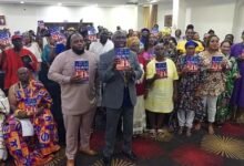 Mr Ben Crump (in suit) and others displaying the book