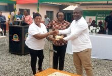 Mr Gunu (right) presenting four - week old chicks to a beneficiary at the launch