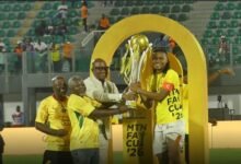 Nations FC skipper Razak Simpson proudly receives the MTN FA Cup trophy from GFA Vice President Mark Addo and FA Cup officials