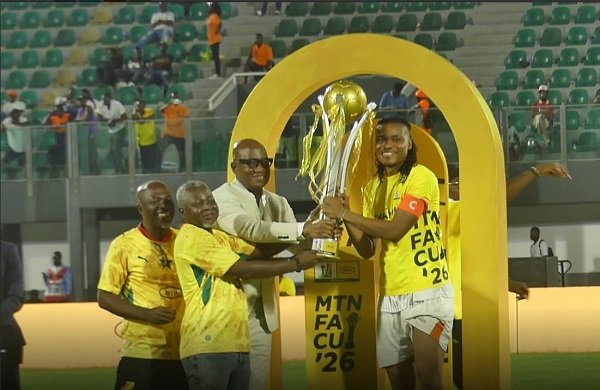 Nations FC skipper Razak Simpson proudly receives the MTN FA Cup trophy from GFA Vice President Mark Addo and FA Cup officials