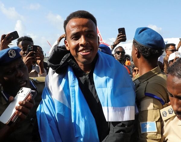 Omar Artan is draped in a Somali flag upon his arrival in the capital, Mogadishu