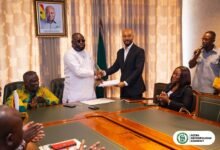 Mr. Allotey (second from left) and Mr. Boateng exchanging the signed MoU document