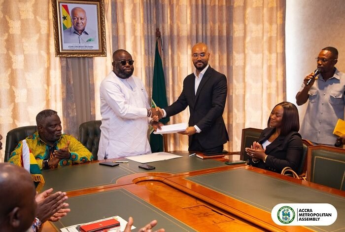 Mr. Allotey (second from left) and Mr. Boateng exchanging the signed MoU document