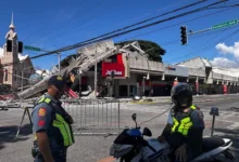 Police gather in front of a collapsed fast food restaurant after a magnitude 7.8 earthquake in General Santos City