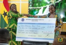 Nana Oye Bampo Addo (left) presenting the dummy cheque to Ms Obuobia Darko-Opoku