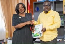 Ms. Lartey (left) presenting a copy of the RTI Law booklet to Mr Akwaboah