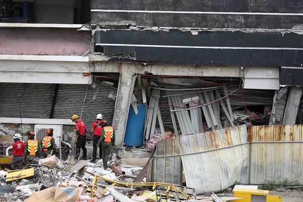 Rescue workers search a building damaged by the earthquake in General Santos city