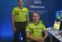 Shaun Evans (left) makes the controversial hand gesture while being introduced as a video assistant referee before Germany v Curaçao