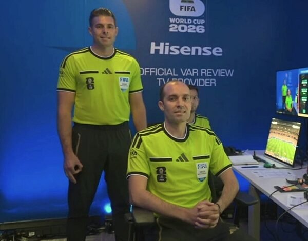 Shaun Evans (left) makes the controversial hand gesture while being introduced as a video assistant referee before Germany v Curaçao