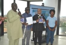 Mr Choudhury (second from right) being assisted by Mr Collison (left) and other participants to launch the report Photo Victor A. Buxtron