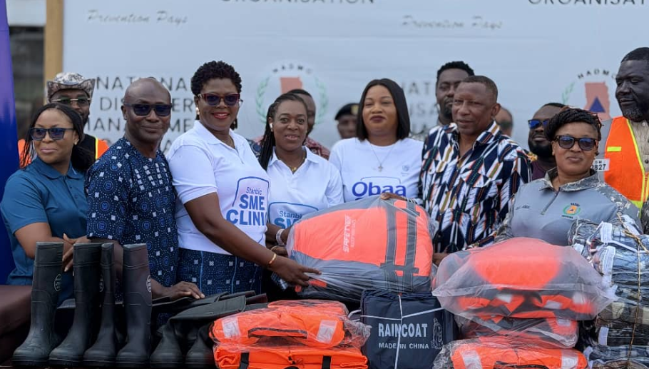 Ms Kaleo-Bioh,(third from left) Head, Business and Commercial Banking, Stanbic Bank presenting the relief items to Mr. Alalzuuga Albert Akuka, Deputy Director General in Charge of Livelihoods and Migration, NADMO