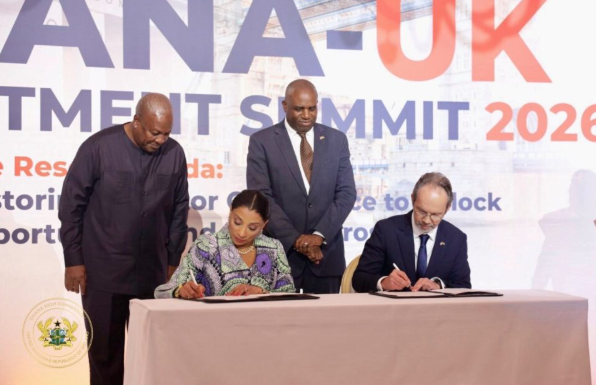 Mrs Sabah Zita Benson (seated left) and Mr. Christian Rogg, British High Commissioner to Ghana signing the MoU. With them is President Mahama (standing left)